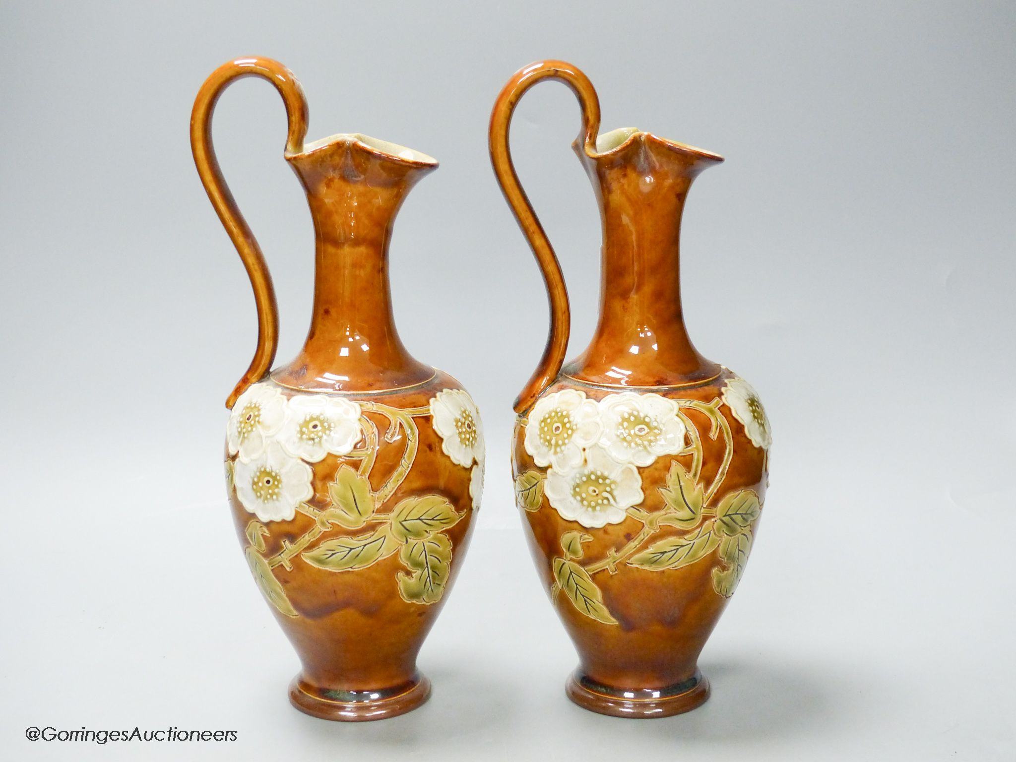 A pair of Royal Doulton stoneware ewers, height 30cm